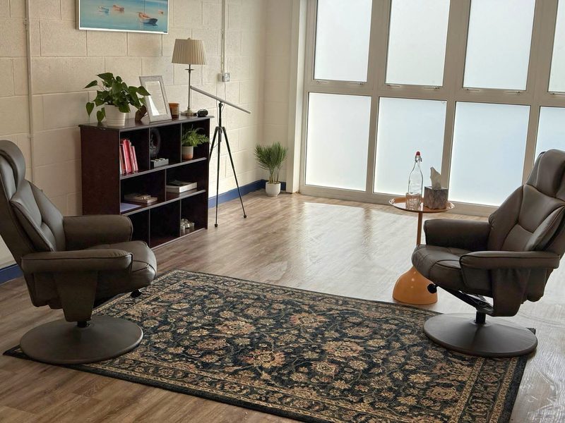 The therapy room, with two comfortable armchairs in a calm, private space and natural light